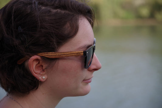 Profil d'une femme portant des lunettes de soleil en bois The Wood Stock