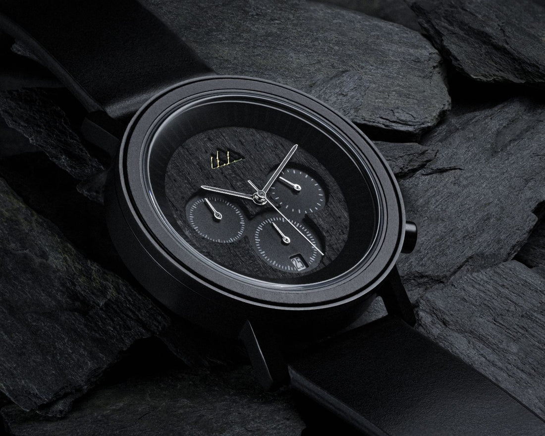 Montre chronographe en bois noir The Wood Stock posée sur de l'ardoise