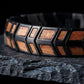 Gros plan sur le motif chevrons du bracelet Orwell Noir Noyer - acier noir brosse et grain du noyer